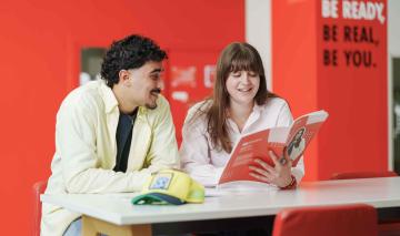 Étudiants consultant une brochure PGE